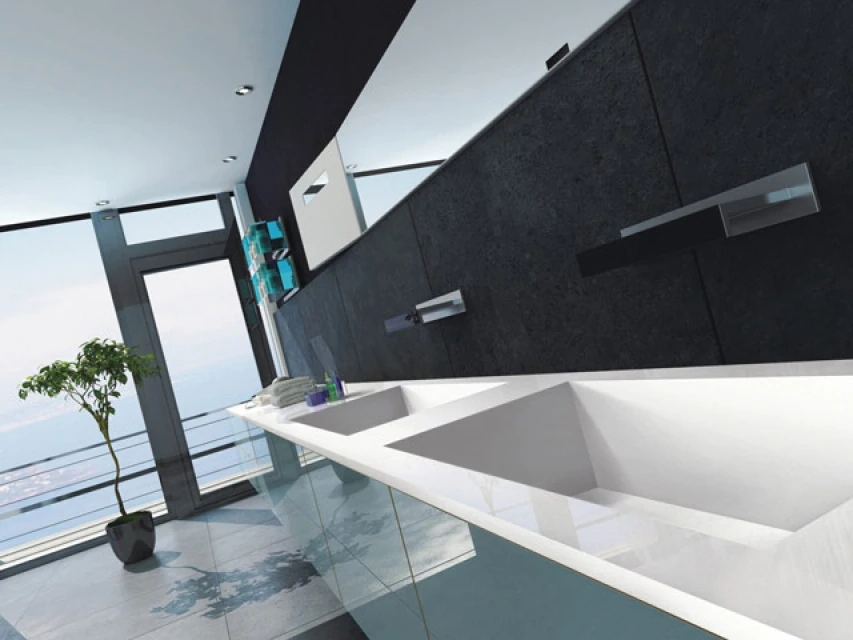 Angular white bathroom basins with chrome taps against a dark wall.