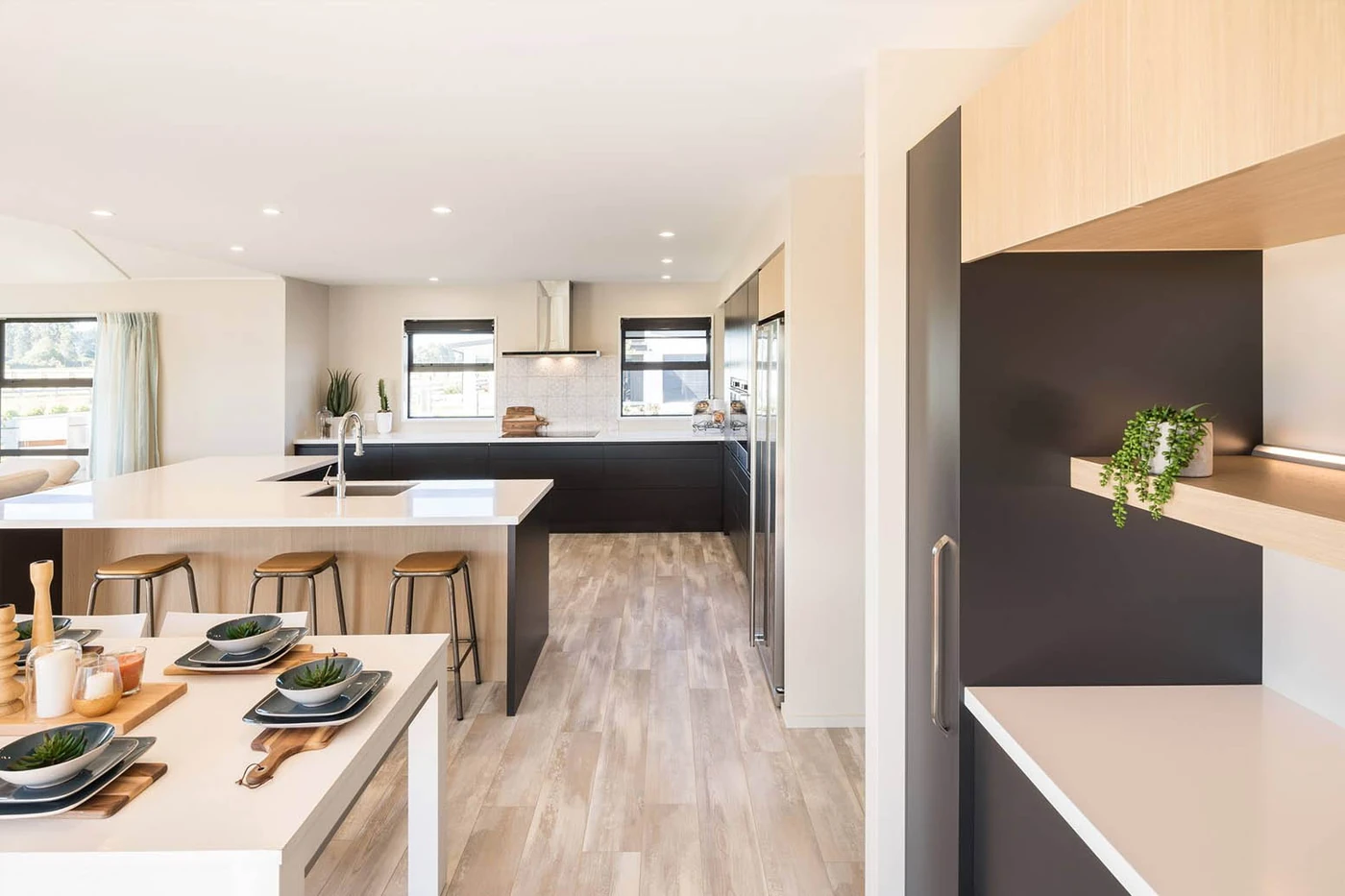 Open-plan kitchen and dining area with light benchtops and warm timber cabinetry.