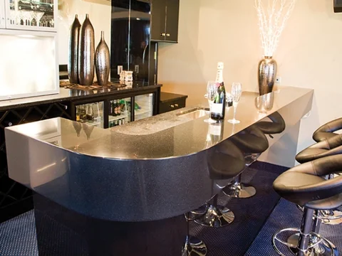Curved light breakfast bar with a dark base and bar stools.