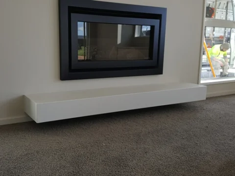 Fireplace with a dark surround above a light hearth.
