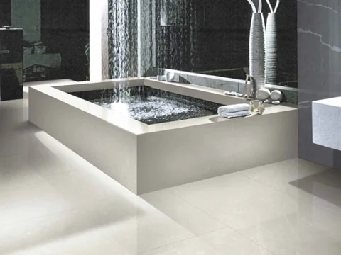 Rectangular bath with a light surround, mosaic wall and candles.