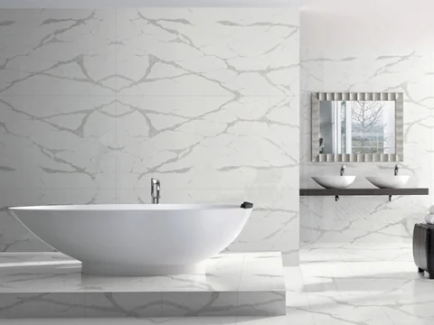 Freestanding white bath against a pale wall with bold veining.