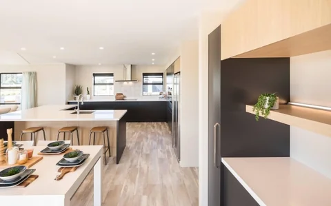 Kitchen and dining area with timber flooring and a light island benchtop.