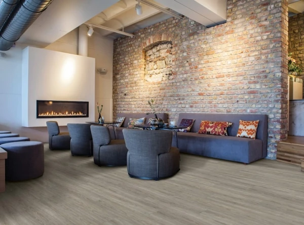 Living room with a brick wall, fireplace, timber floor and blue seating.