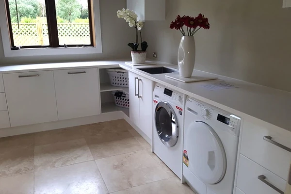 White laundry benchtop with a sink, washing machine and dryer.